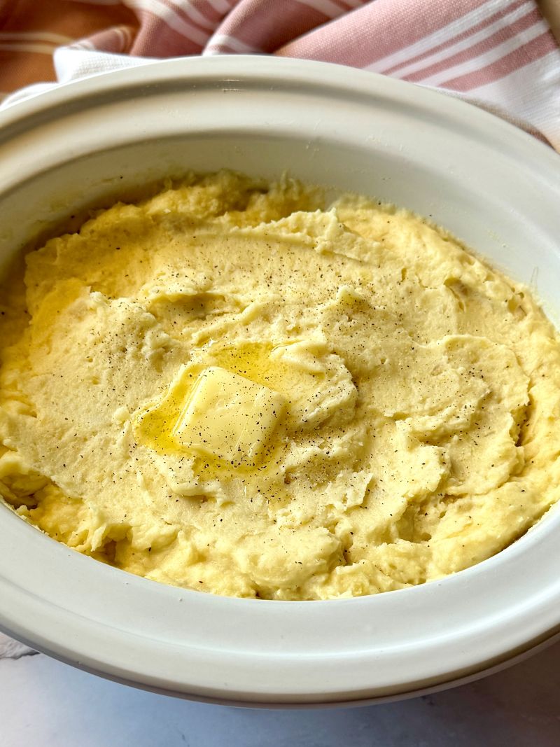 Mashed potatoes in the slow cooker with butter on top. 