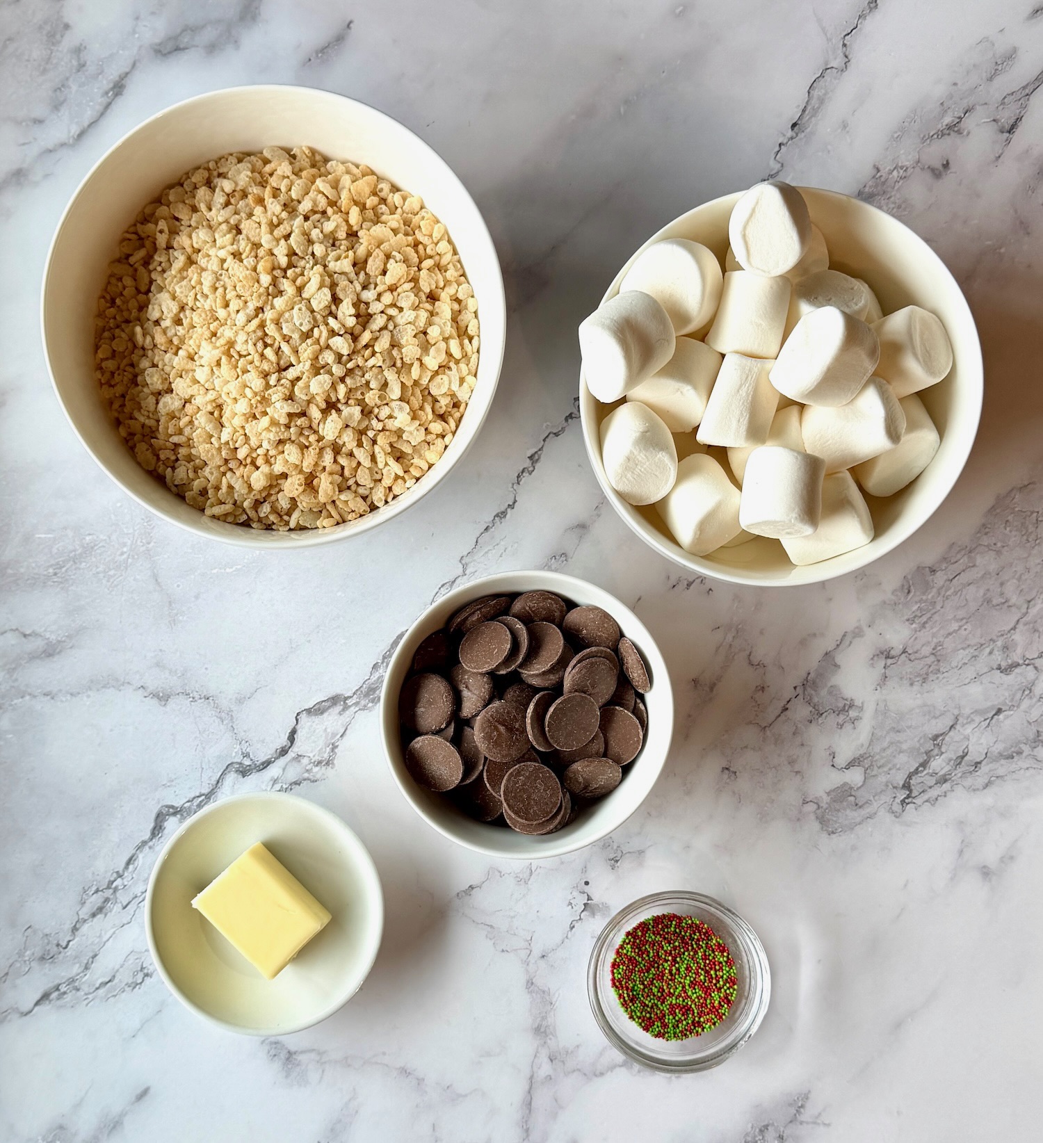 Ingredients displayed for Mini chocolate dipped rice Krispie treats. Rice Krispie cereal, marshmallows, Melting chocolate wafers, butter, and sprinkles. 