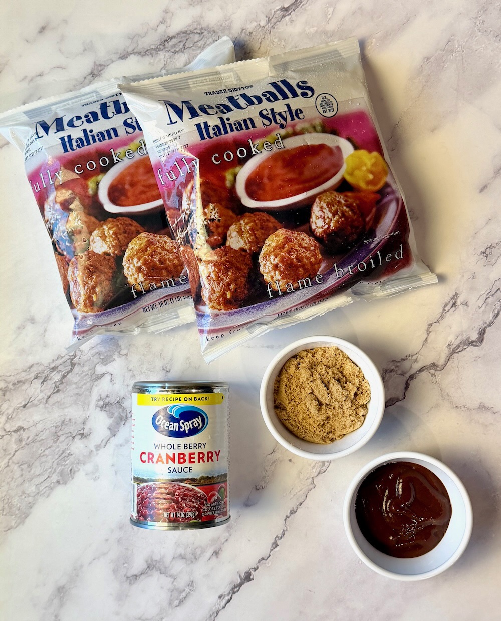 Ingredients for slow cooker cranberry meatballs. Frozen meatballs, cranberry sauce, brown sugar, and BBQ sauce.