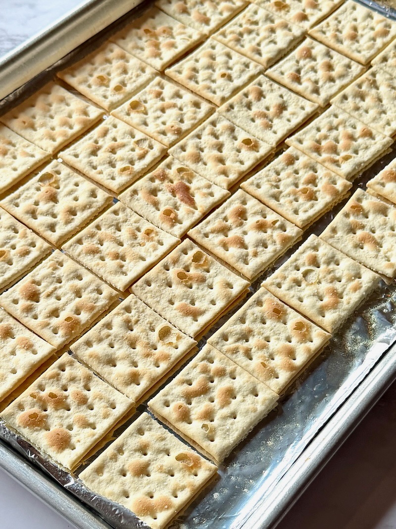 Saltine crackers in a single layer on a sheet pan.