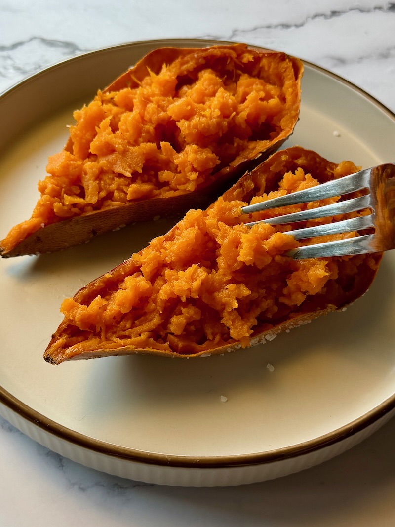 Sweet potato fluffed in half and fluffed with fork. 