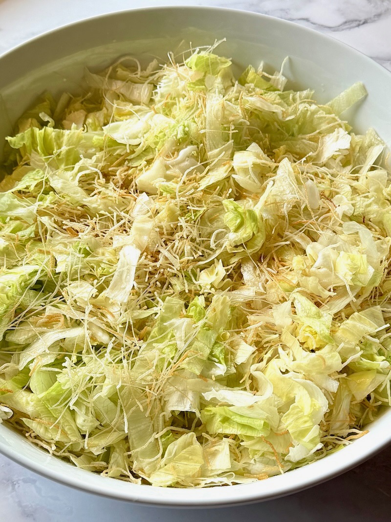 Lettuce mixed with cooked rice noodles for Chinese chicken salad