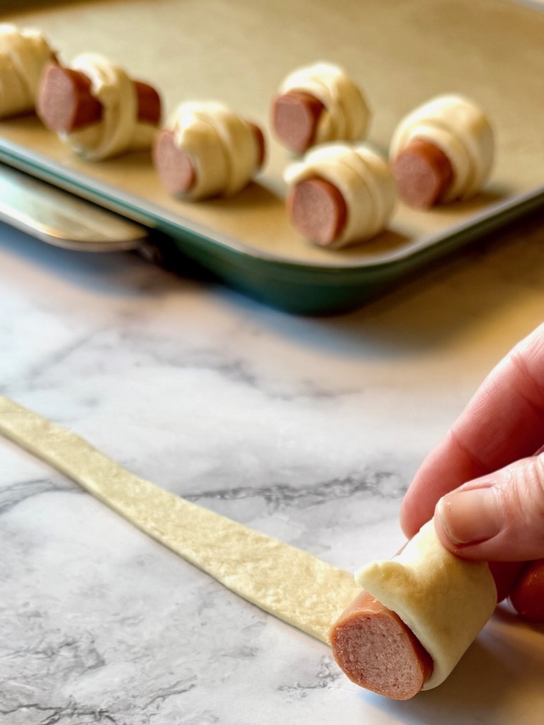 Hot dog rolled up in a crescent triangle.