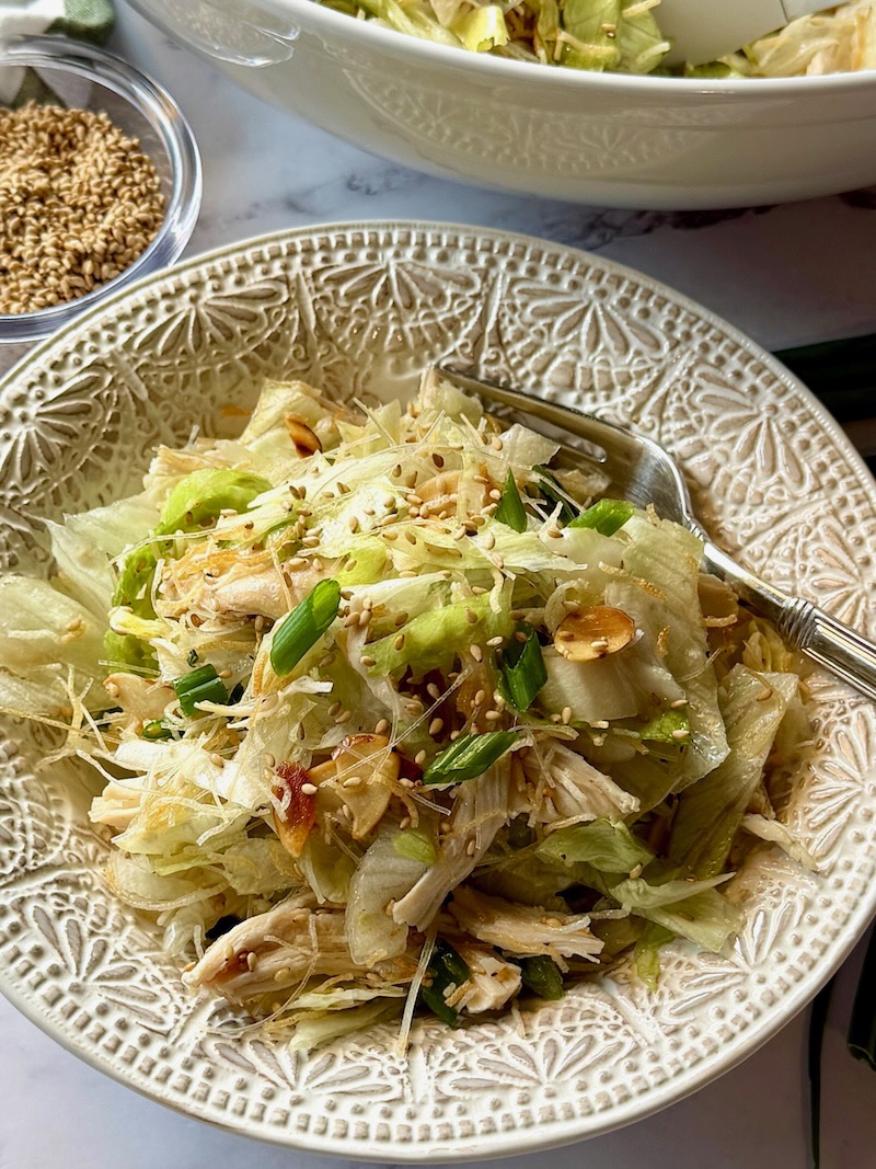 Chinese chicken salad in a serving bowl with a fork.