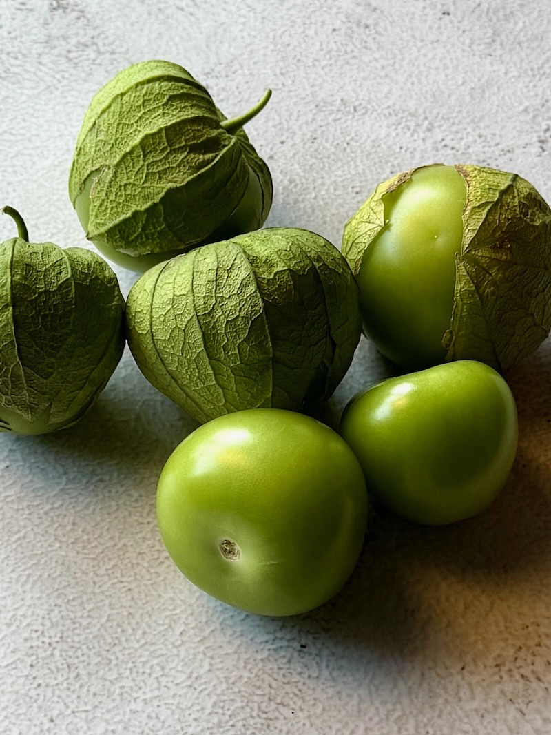 Picture of tomatillos with some in their husks.