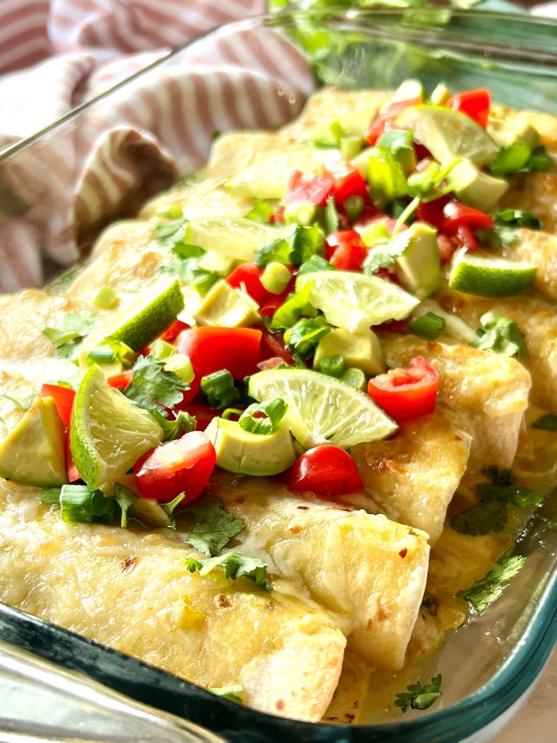 A pan of creamy chicken spinach enchiladas.