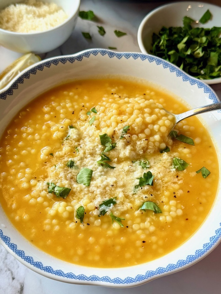 Bowl of pastina soup with parmesan cheese and parsley on top