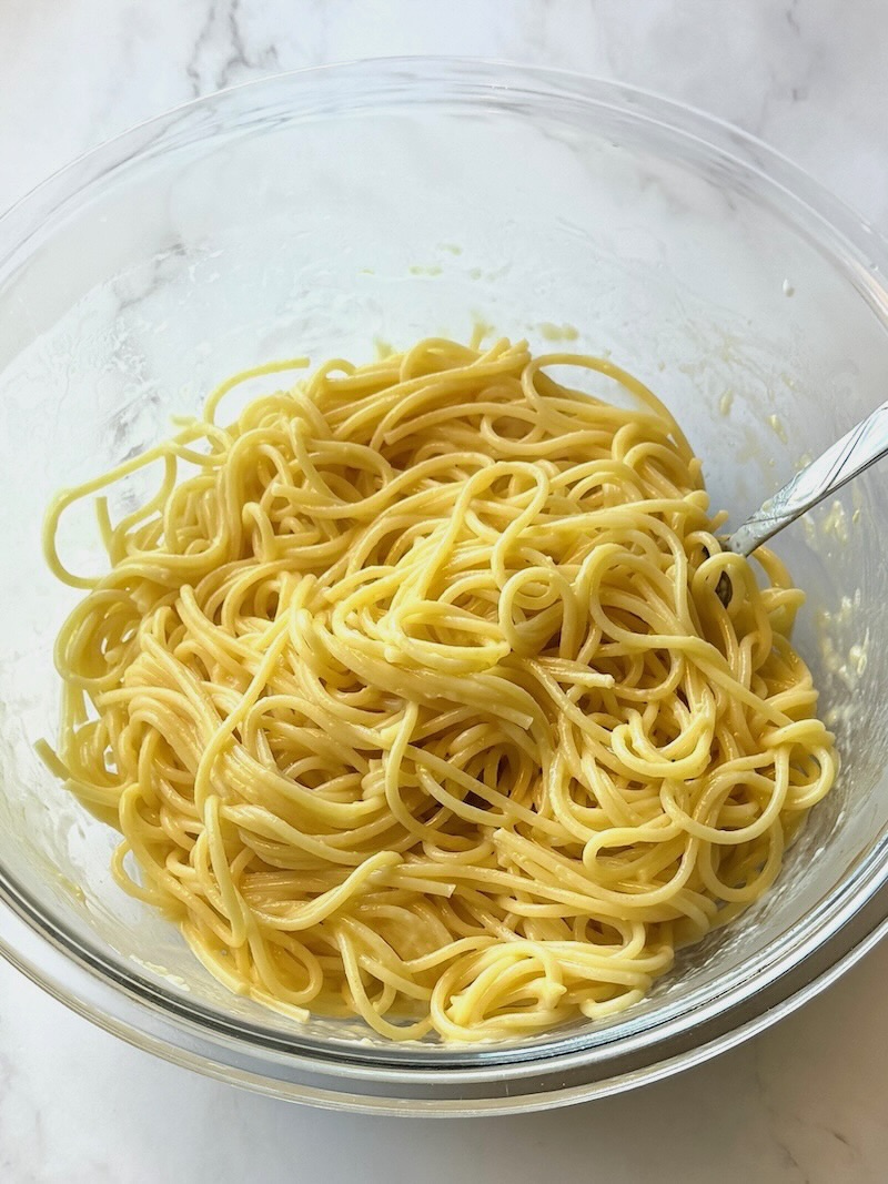 Cooked spaghetti cooked and combined with egg, parmesan cheese, and butter. 