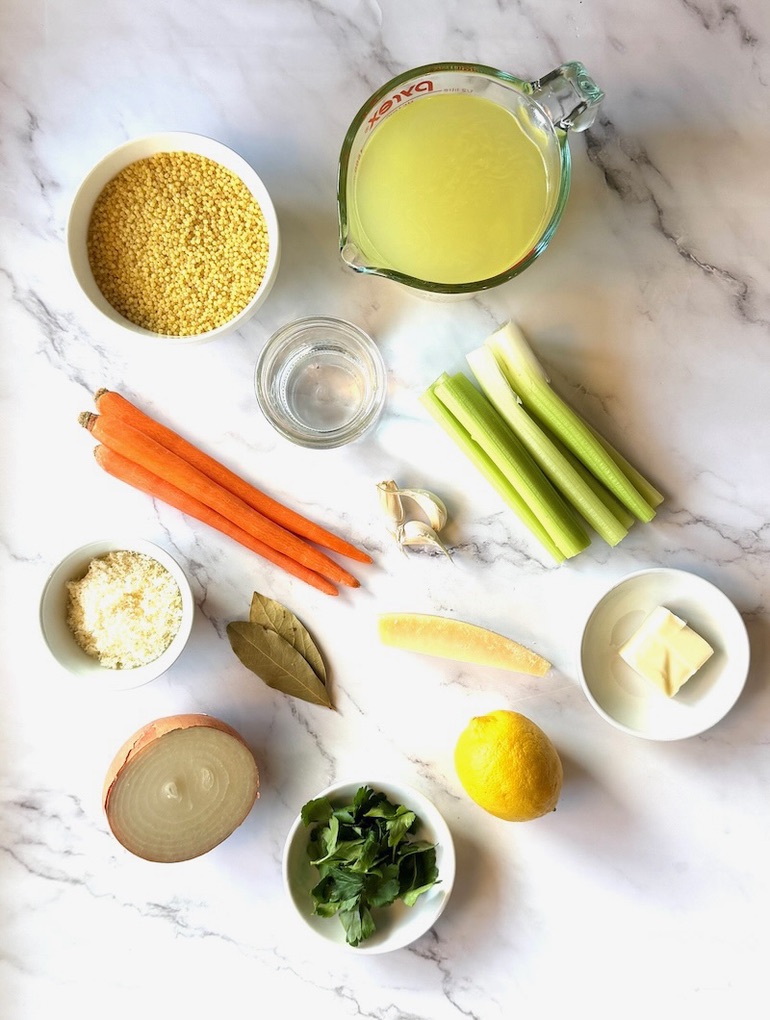 Ingredients displayed for Italian pastina soup. Pasta, chicken broth, water, carrots, celery, garlic, onion, parmesan cheese and rind, bay leaves, butter, lemon. 