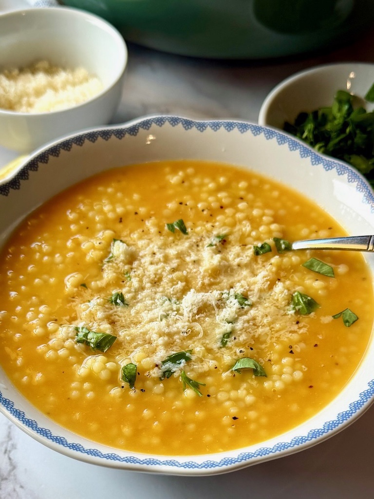 A bowl and spoon with pastina soup