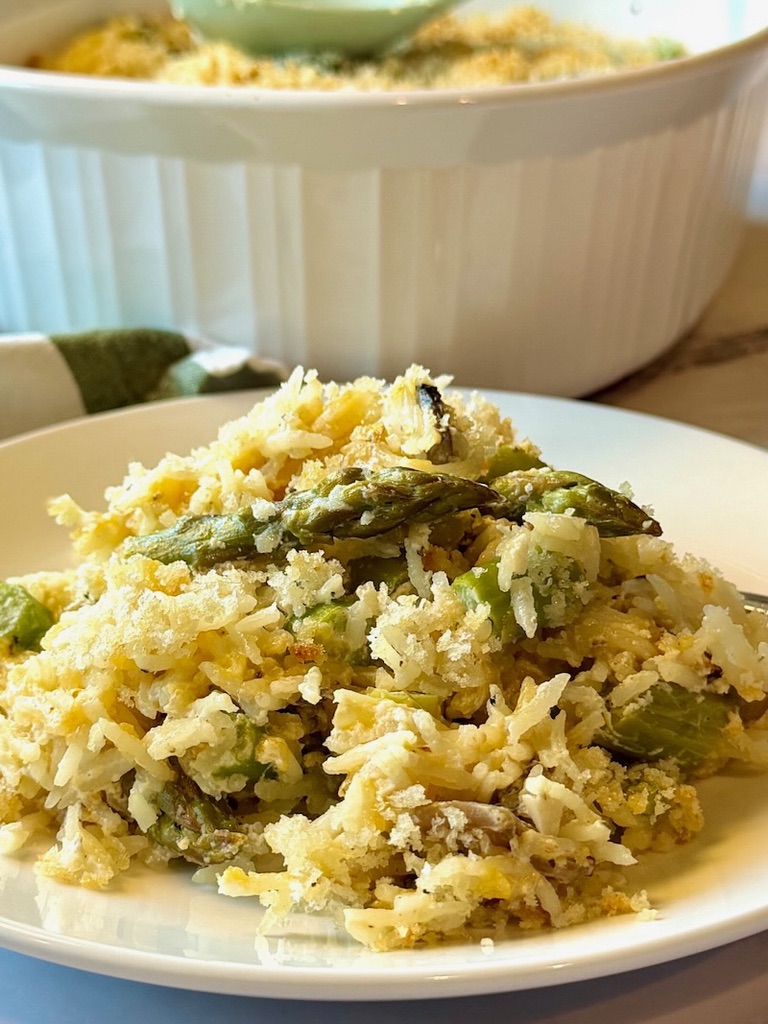 Cheesy asparagus rice casserole plated on a serving plate. 