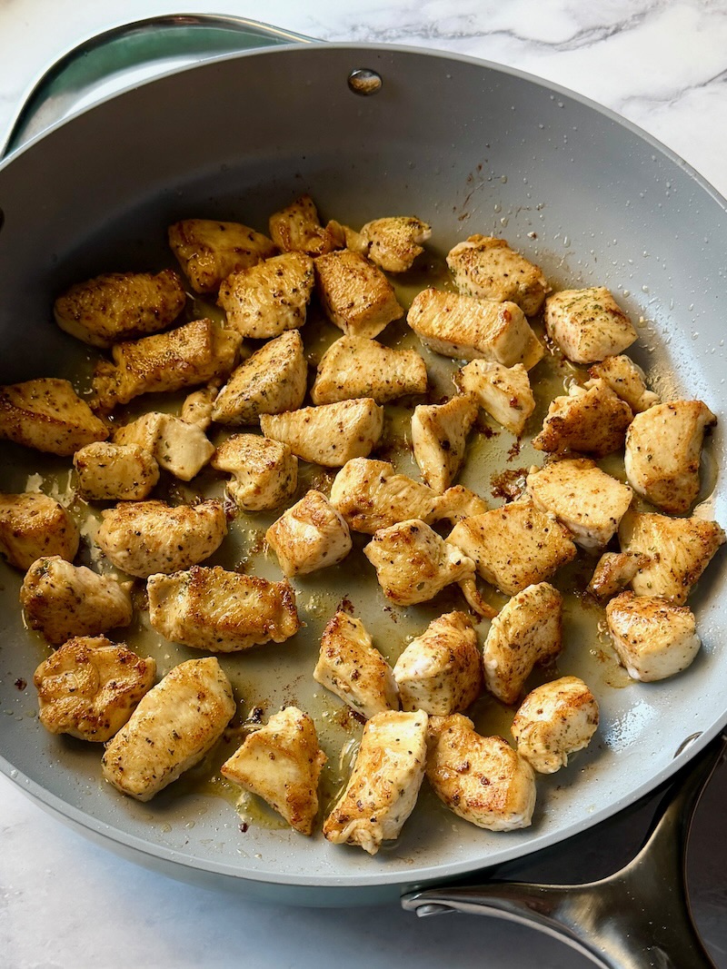 Browned chicken in a large skillet. 
