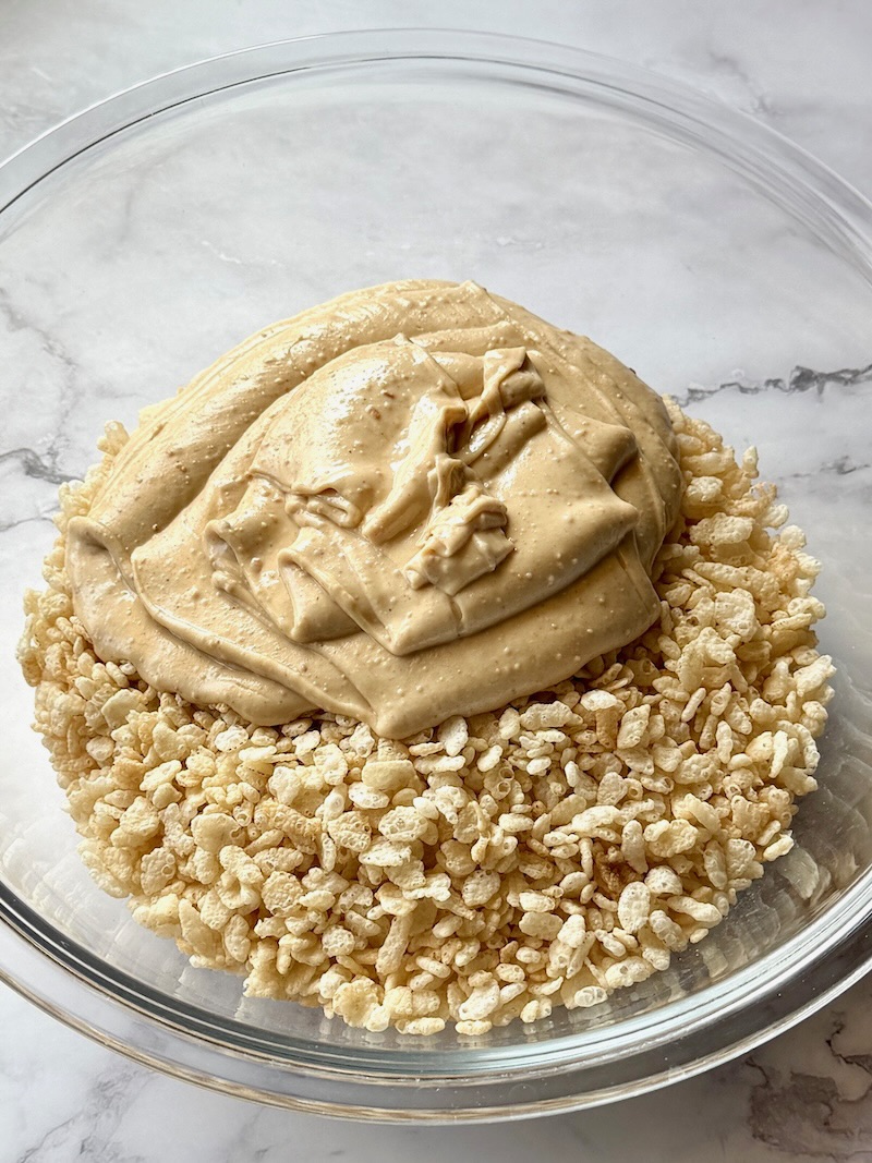 Melted chocolate and peanut butter in the bowl with rice krispies