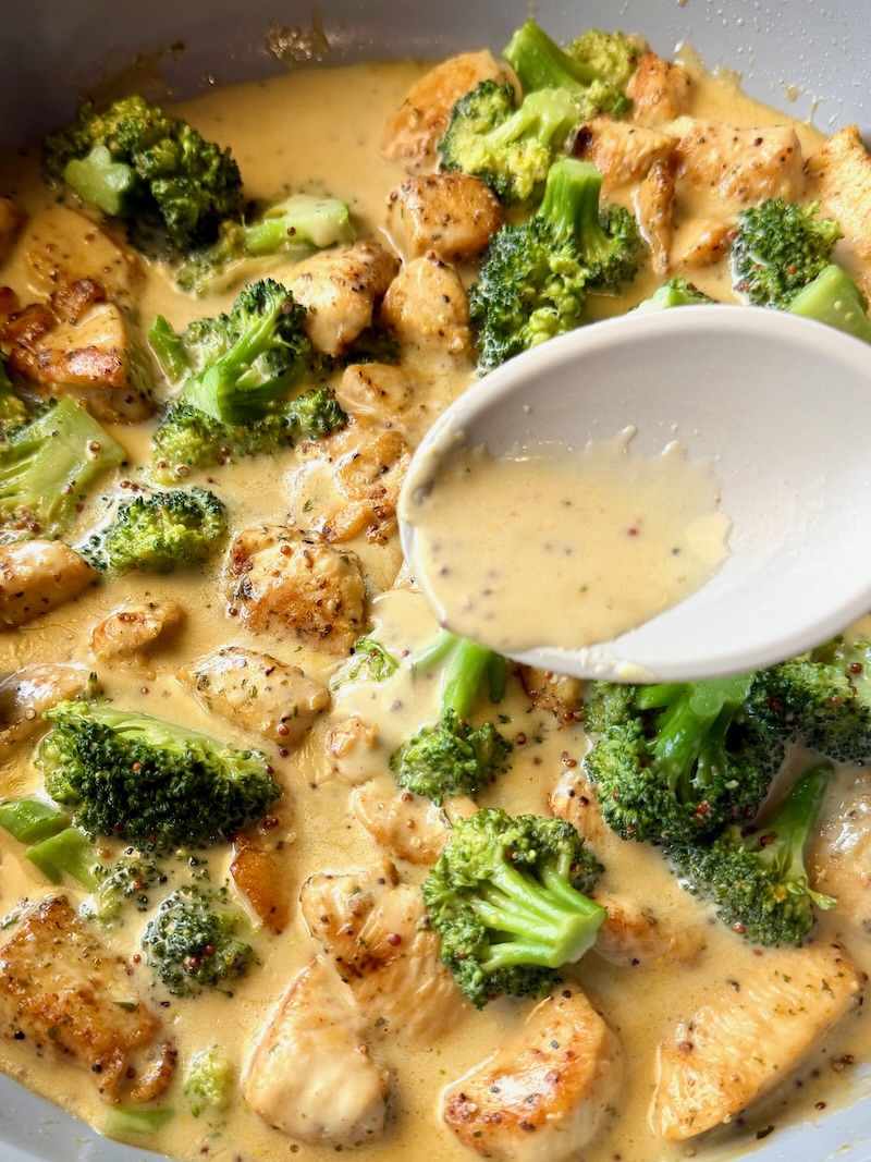 honey mustard sauce poured over the chicken and broccoli with a spoon.