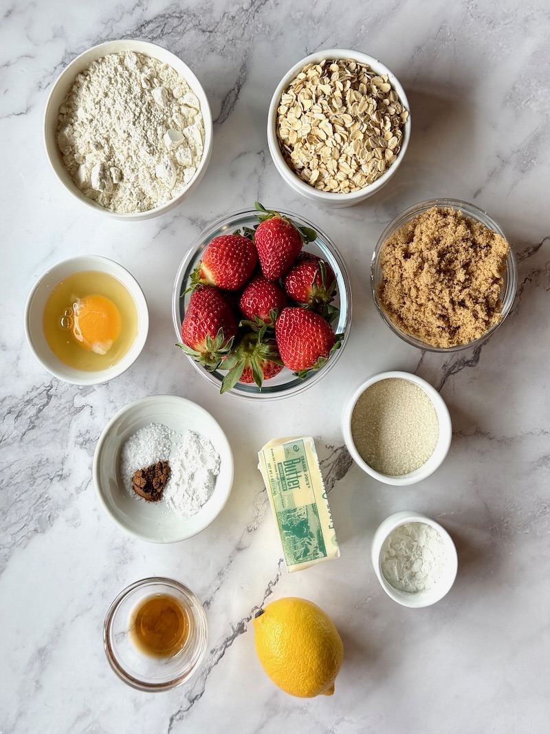 Ingredients for Fresh strawberry crumble bars. All-purpose flour, oats, brown sugar, egg, strawberries, sugar, butter, vanilla extract, lemon juice, cornstarch, salt, and cardomom.