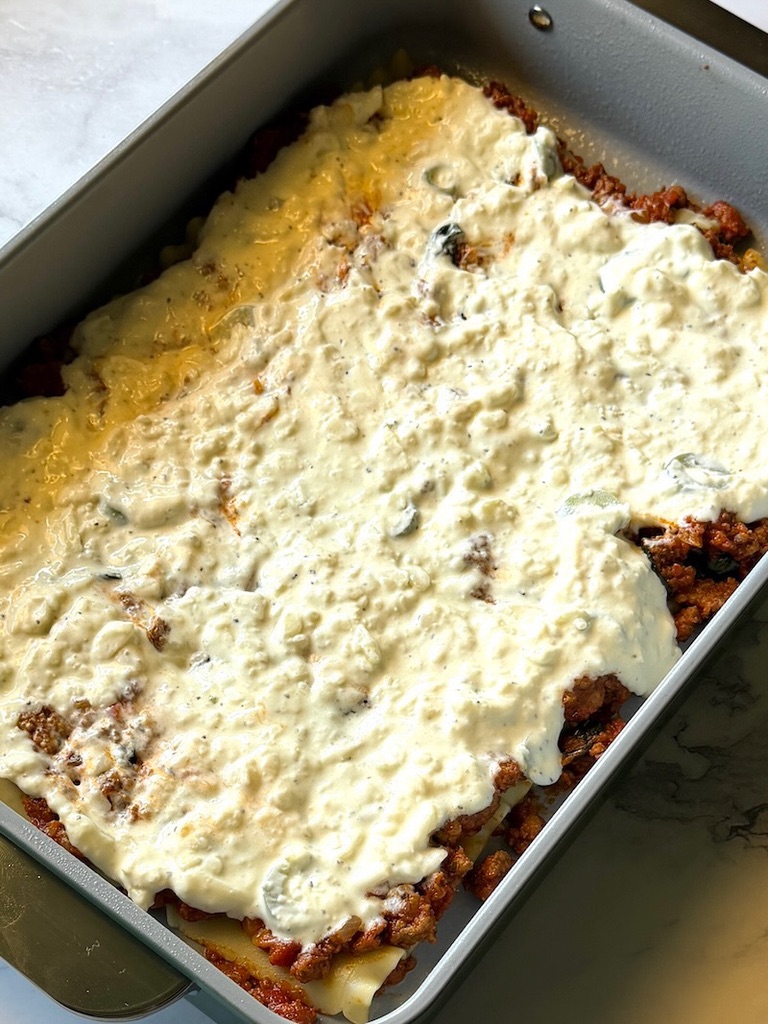 Sour cream cheese sauce spread on top of meat sauce. 