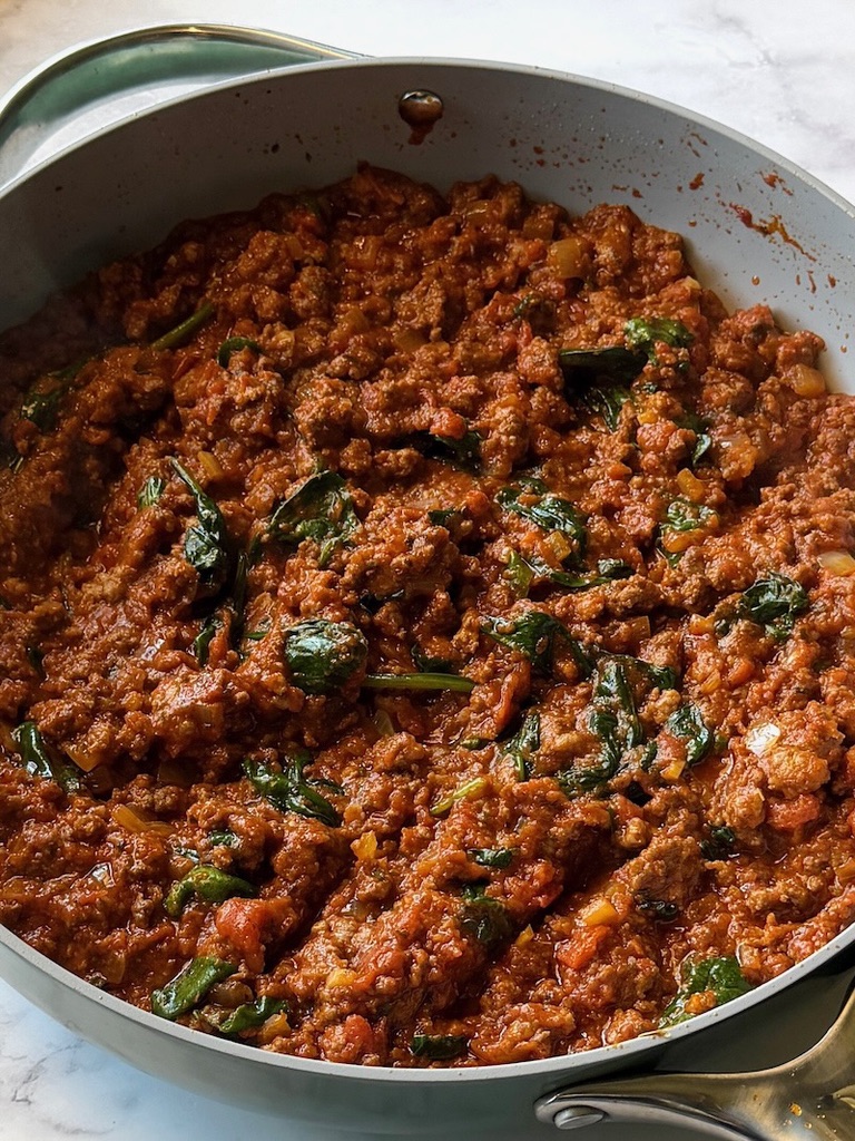 Spinach wilted in the meat sauce.