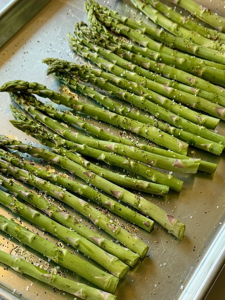 Uncooked asparagus with olive oil, salt and pepper