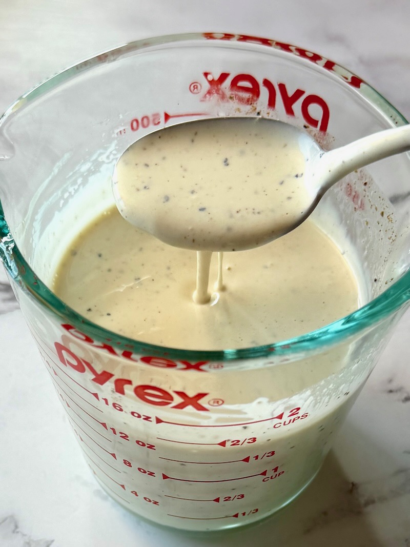 Dressing combined in a measuring cup with a spoon