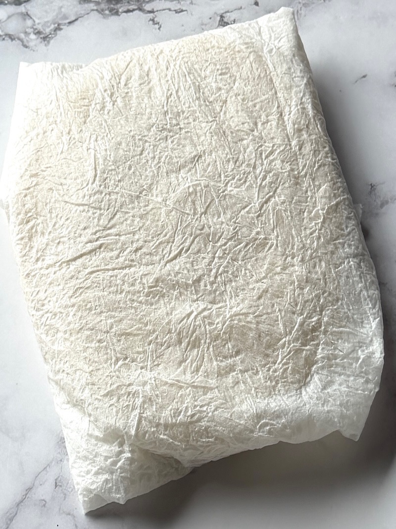 Corn tortillas wrapped in paper towels. 
