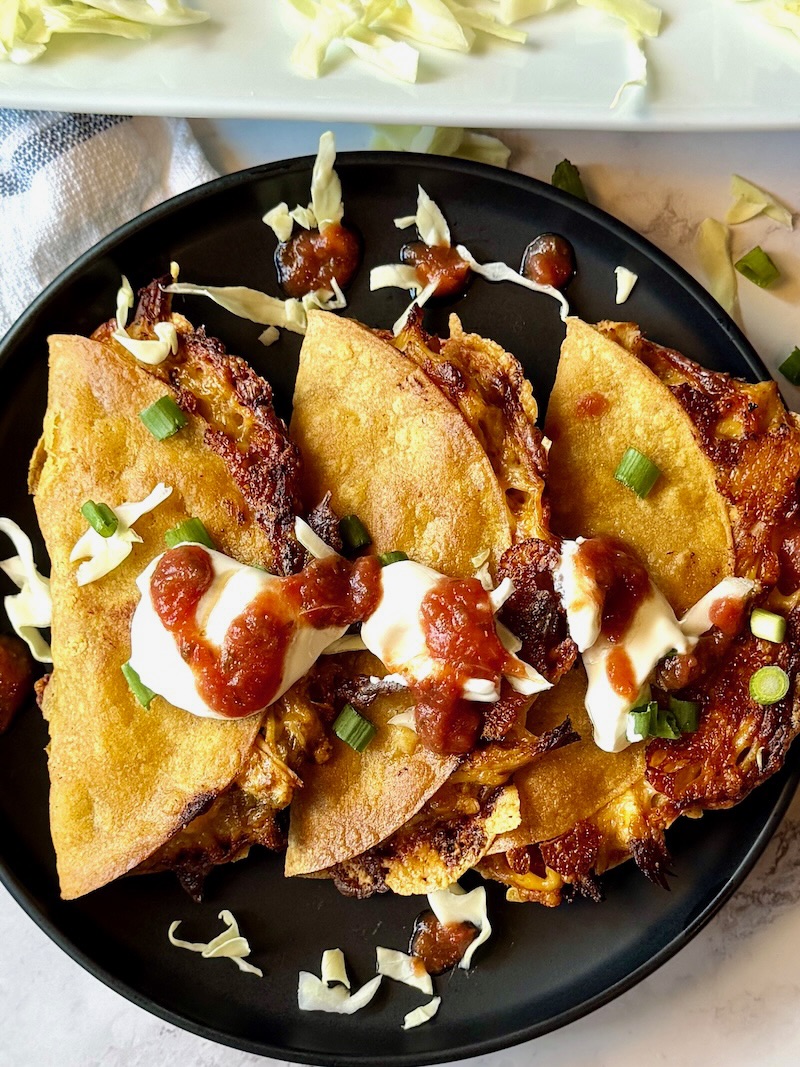 Crispy oven baked chicken tacos assembled and topped with sour cream and salsa