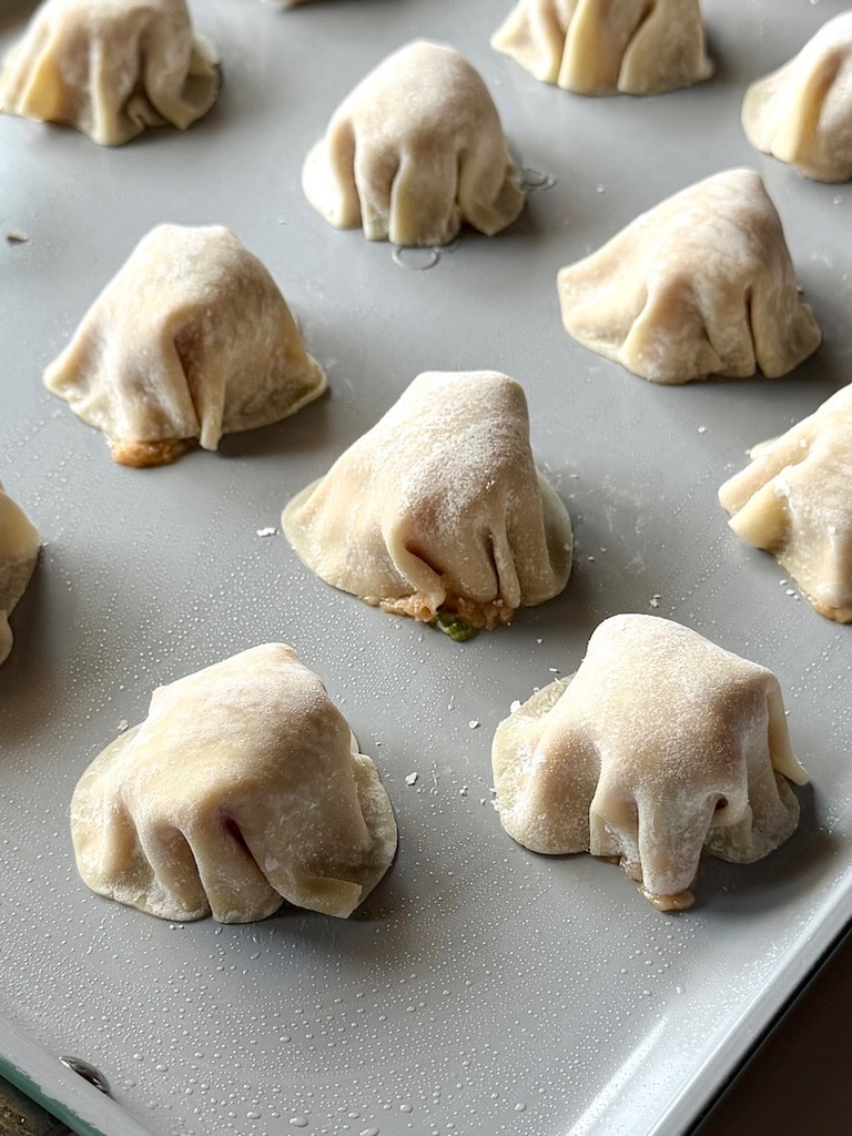 Sheet pan with assembled dumplings.