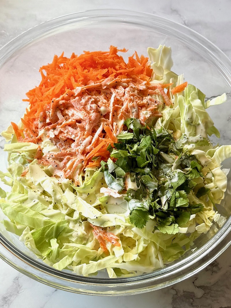 Cabbage, carrots, and cilantro in a serving bowl.