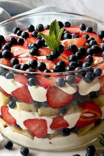 Berry trifle with whipped cream cheese layer in a trifle bowl.