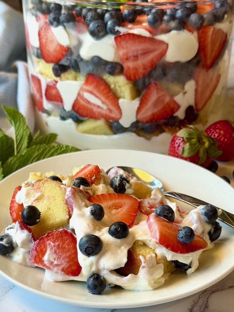 Berry trifle plated on a small serving plate with a spoon.