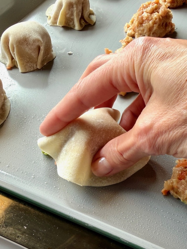 Round potsticker wrapper set over a meatball.