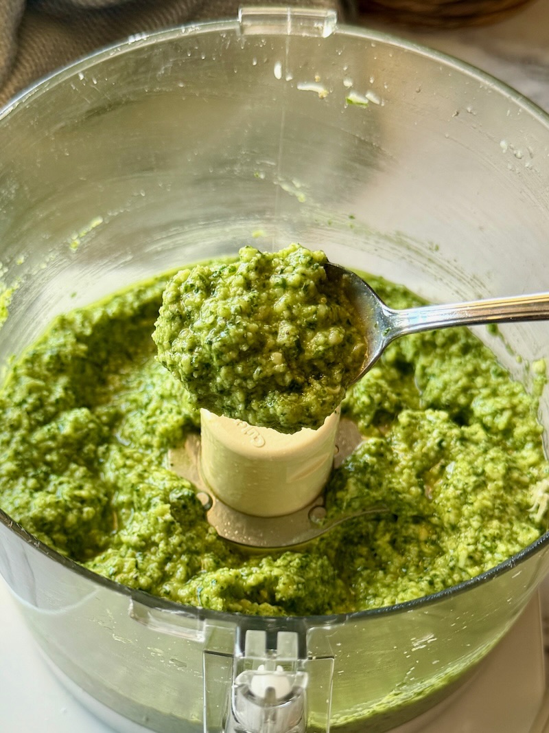 Arugula pesto blended in the food processor with a spoon