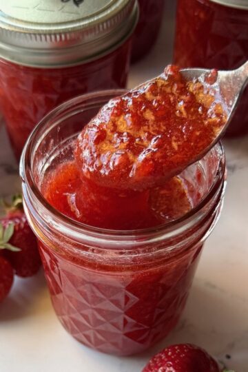 Strawberry jam in a jar with a spoon