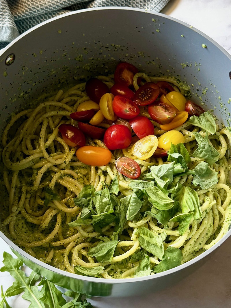 Cherry tomatoes and fresh basil added to the pesto pasta