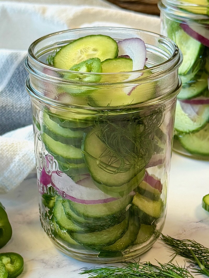 Cucumbers, onion, jalapeno, and dill in a mason jar.