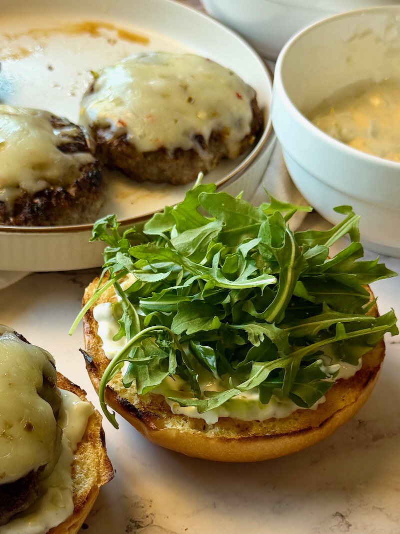 Arugula on top of the beef patty. 