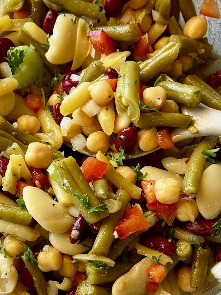 marinated bean salad in a serving bowl with a spoon