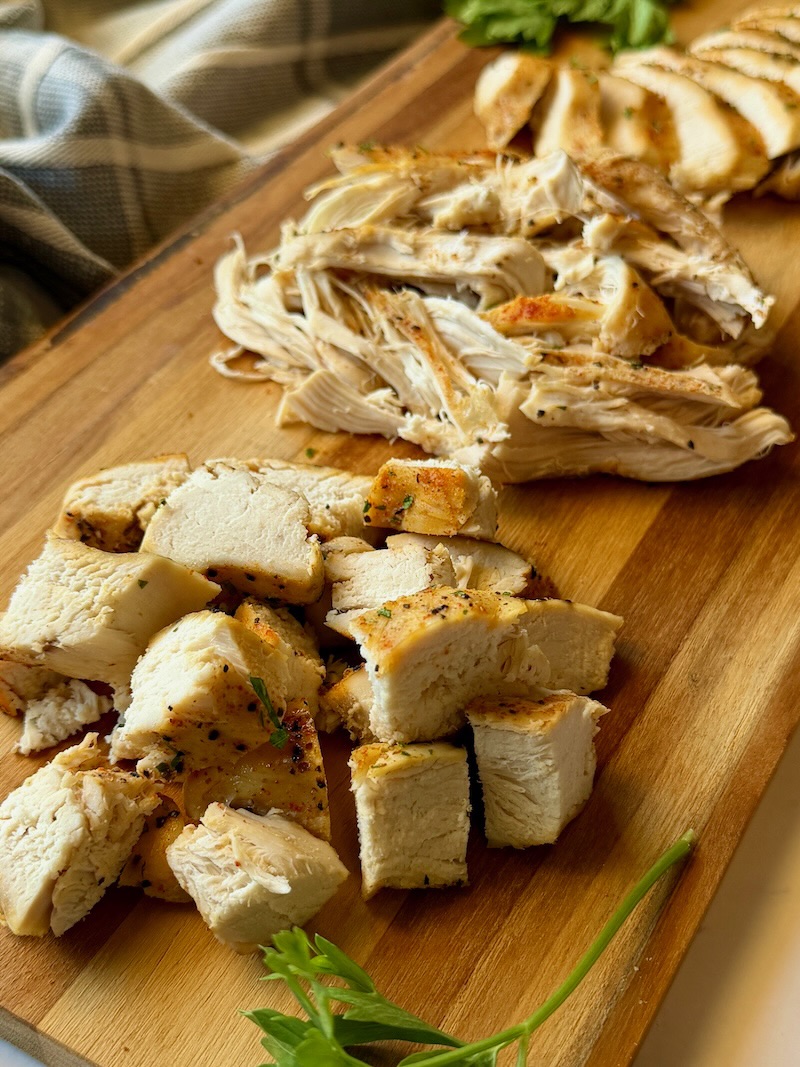 cooked chicken on a board diced, shredded, and sliced