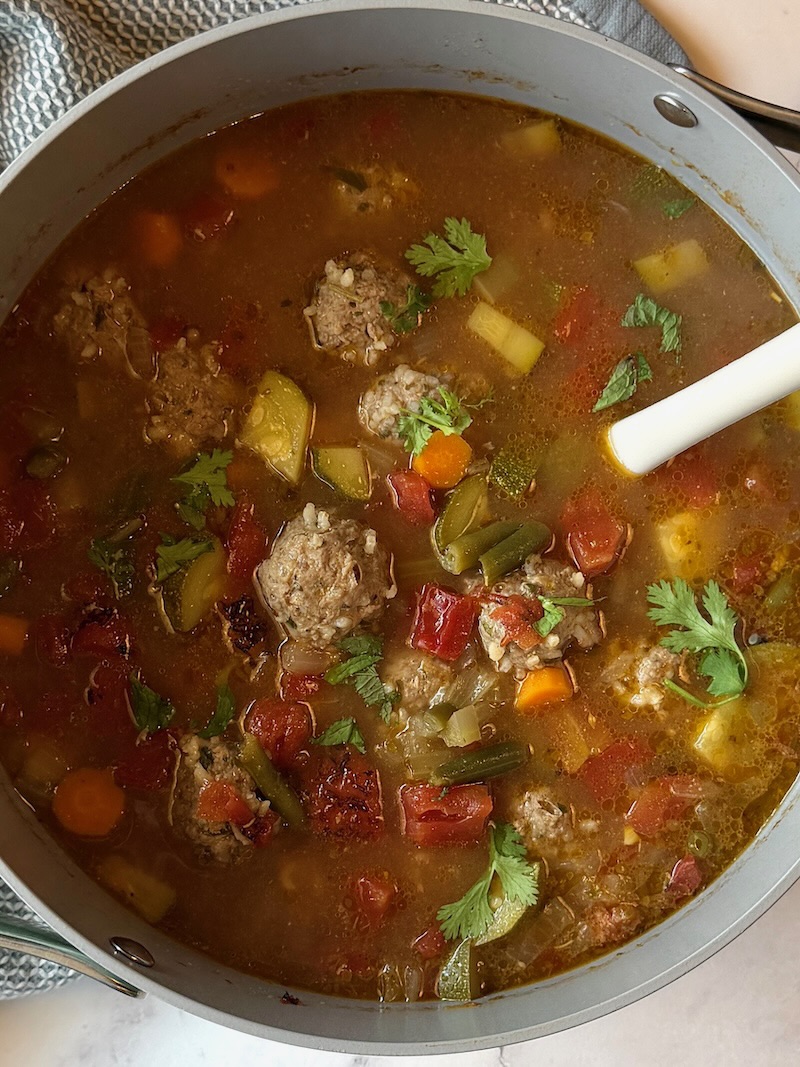 Albondigas soup in a large pot with a spoon