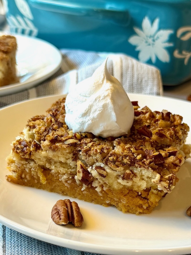 Slice of pumpkin dump cake with whipped cream on top