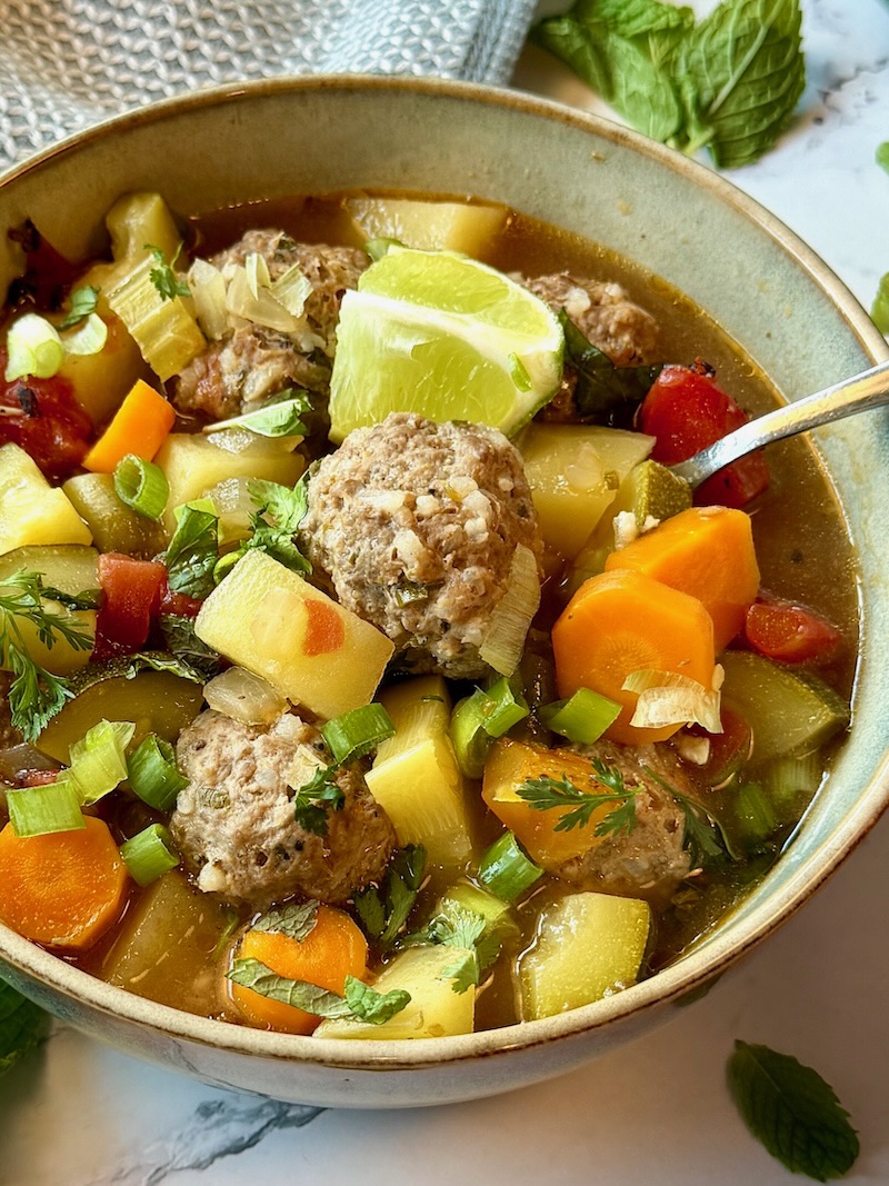 Mexican meatball soup in a bowl with a spoon