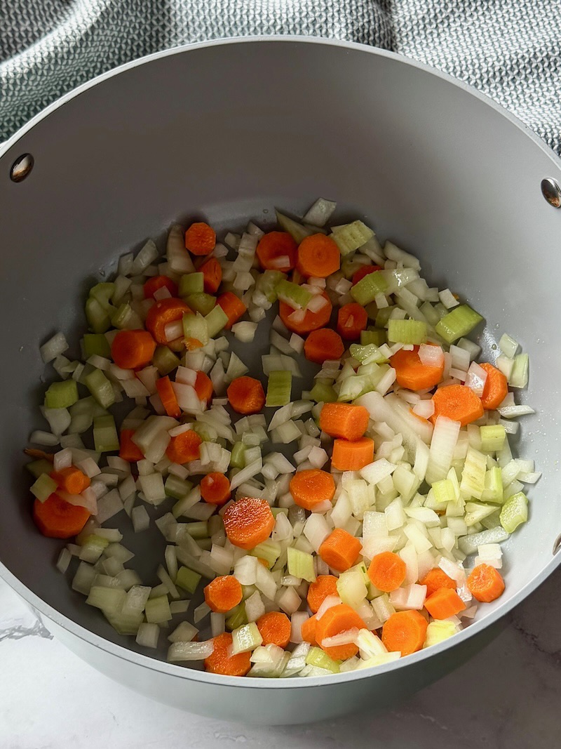 onions, carrots, celery, and garlic in a soup pot with olive oil